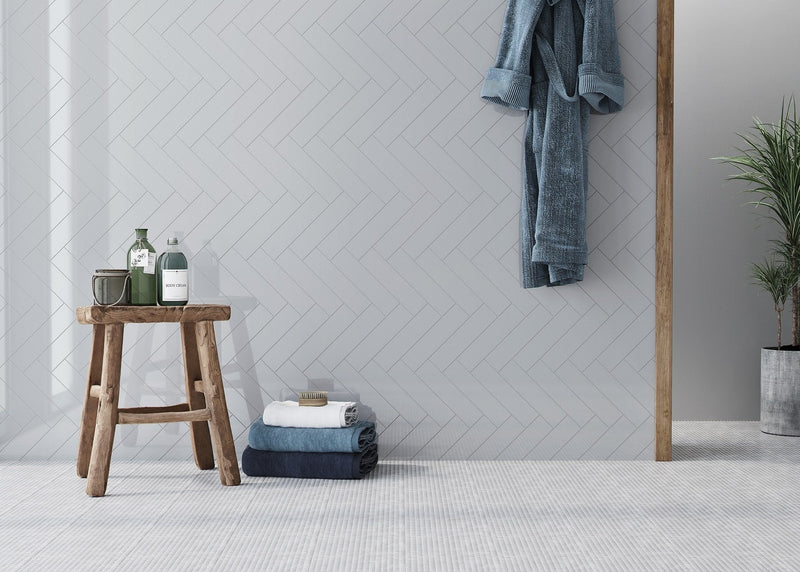 White subway tile installed on a interior wall in a herringbone pattern