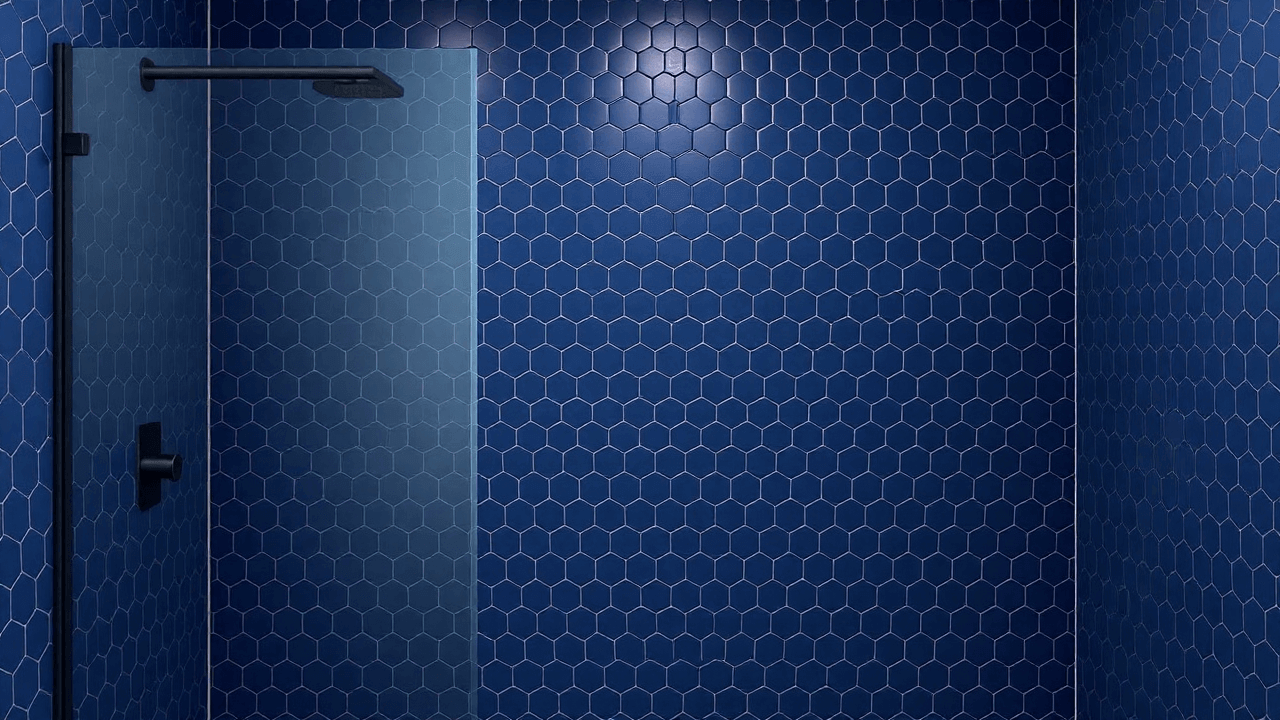 Blue hexagon tile shower with glass enclosure