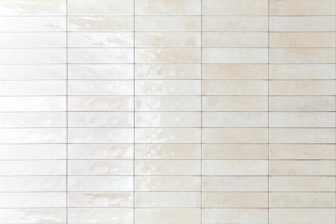 City Distressed Subway Tile Ivory Glossy 2x10 installed on a wall